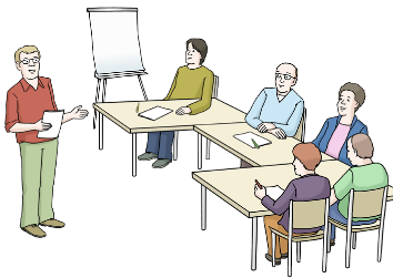 Auf dem Bild sieht man mehrere Menschen, die an einem Tisch sitzen. Vorne steht eine weiße Tafel. Neben dem Tisch steht ein Mann, der etwas erklärt. Auf dem Bild sieht man mehrere Menschen, die an einem Tisch sitzen. Vorne steht eine weiße Tafel. Neben dem Tisch steht ein Mann, der etwas erklärt.